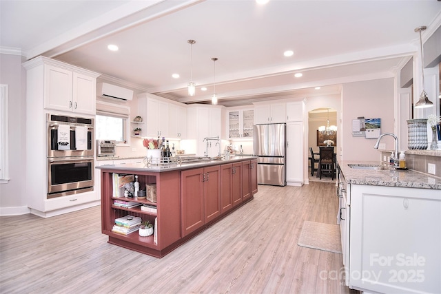 kitchen with arched walkways, beamed ceiling, stainless steel appliances, open shelves, and a sink