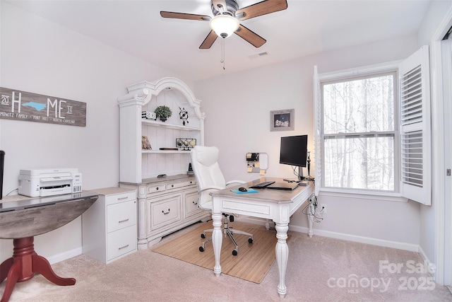 office area with baseboards, ceiling fan, visible vents, and light colored carpet