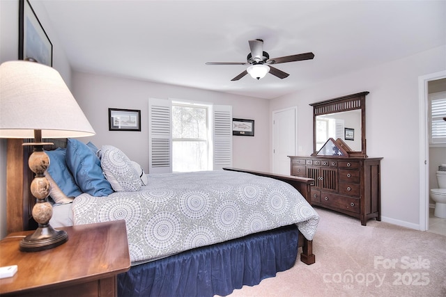 bedroom with ceiling fan, connected bathroom, baseboards, and carpet flooring