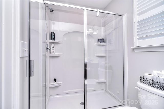 full bath featuring a shower stall and toilet