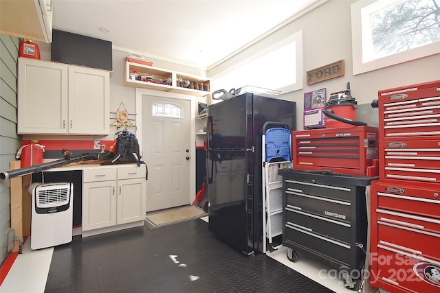 kitchen with freestanding refrigerator, white cabinets, and plenty of natural light