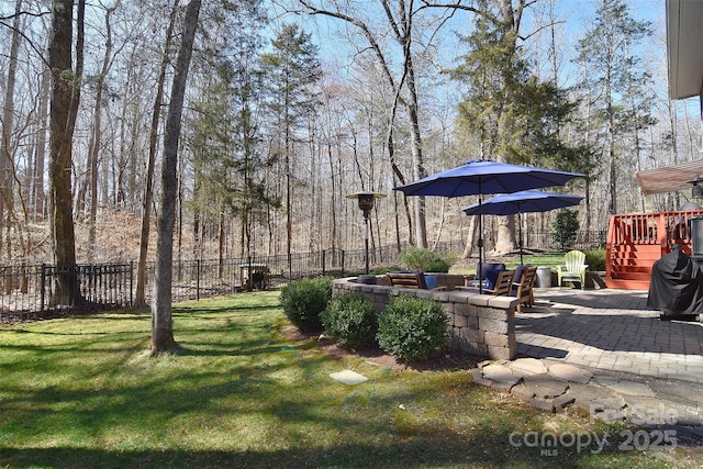 view of yard featuring a wooden deck, fence, and a patio