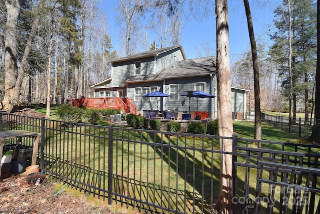 back of property featuring a fenced backyard, a deck, and a yard