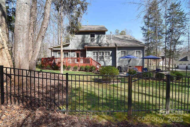 view of front of house with fence private yard, a deck, and a front yard