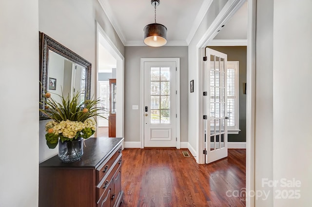 entryway featuring dark wood-style floors, visible vents, ornamental molding, and baseboards