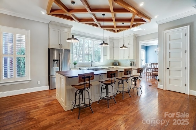 kitchen with dark wood-style floors, backsplash, high quality fridge, coffered ceiling, and a kitchen breakfast bar