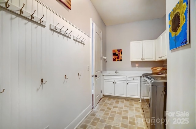 interior space with light tile patterned floors, light countertops, white cabinets, a sink, and separate washer and dryer