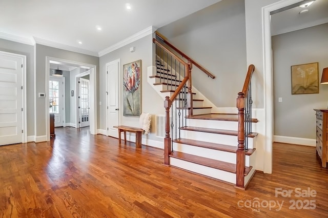 foyer entrance with recessed lighting, stairway, ornamental molding, wood finished floors, and baseboards