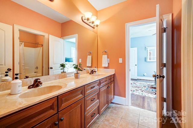 full bathroom featuring double vanity, baseboards, a sink, and tile patterned floors