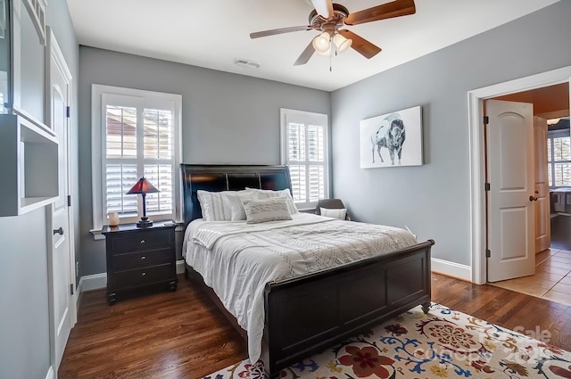 bedroom featuring dark wood-type flooring, multiple windows, visible vents, and baseboards