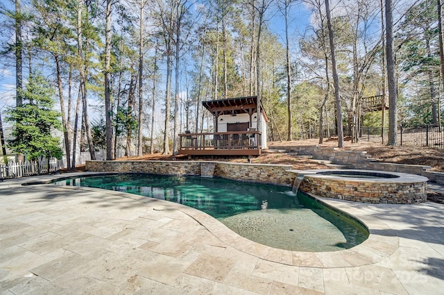 view of swimming pool featuring a fenced backyard, a pool with connected hot tub, a patio, and a wooden deck