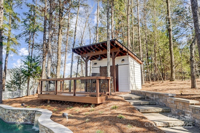 view of outbuilding featuring a pool, an outbuilding, and fence