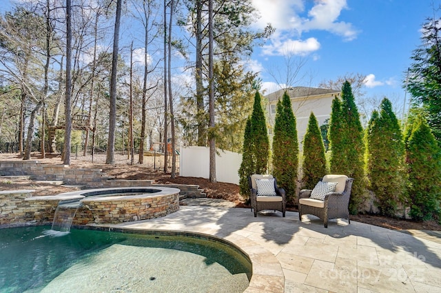 view of patio / terrace featuring a fenced in pool, fence, and an in ground hot tub