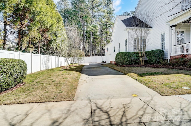 view of side of property featuring a lawn and fence