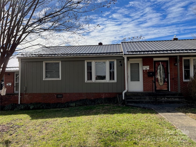 view of front facade with entry steps, crawl space, metal roof, and a front lawn