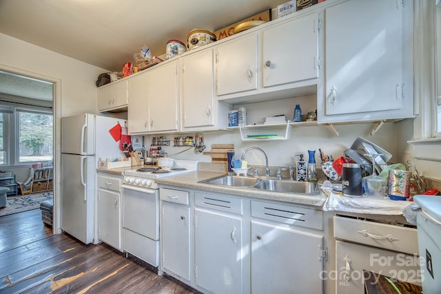 kitchen with white cabinets, white appliances, light countertops, and a sink