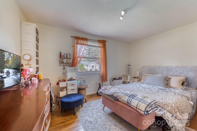 bedroom featuring a textured ceiling and wood finished floors