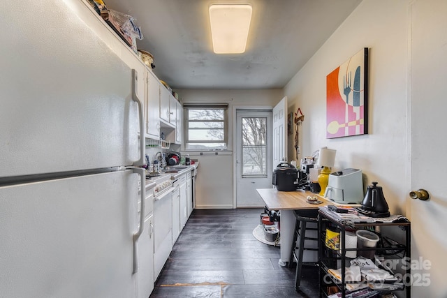 kitchen with light countertops, dark wood-style flooring, freestanding refrigerator, and white cabinetry