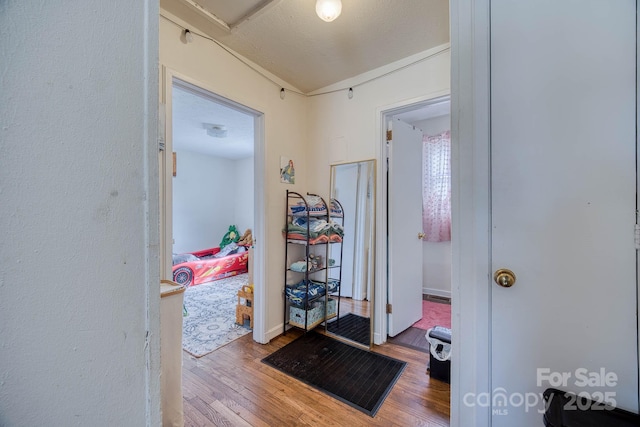 hall with baseboards and wood finished floors