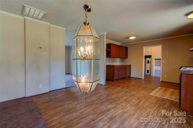 kitchen featuring crown molding, visible vents, water heater, a textured ceiling, and wood finished floors