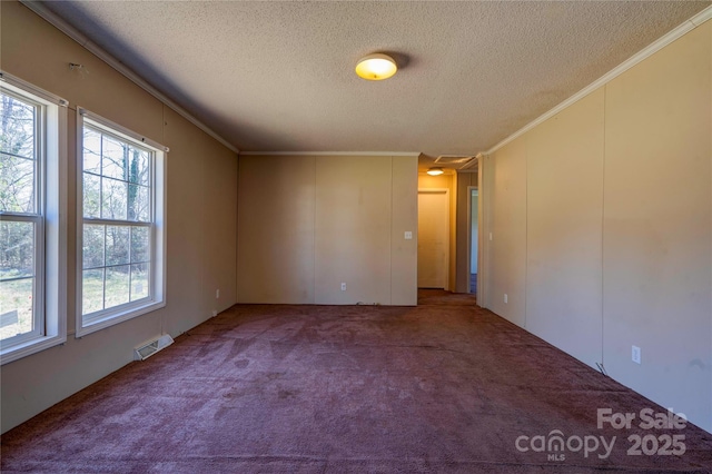 carpeted empty room with visible vents, a textured ceiling, and ornamental molding