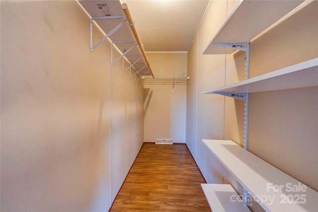 walk in closet featuring visible vents and wood finished floors