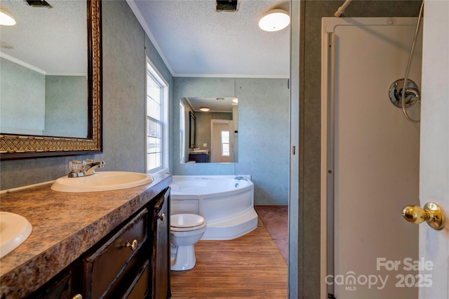 full bath featuring a garden tub, crown molding, a sink, a textured ceiling, and wood finished floors