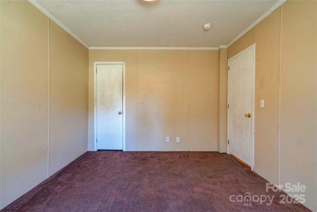 spare room featuring ornamental molding, carpet flooring, and a textured ceiling