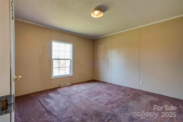 carpeted spare room featuring a textured ceiling, visible vents, and crown molding