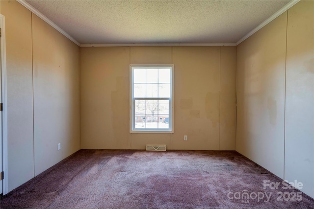 carpeted spare room with crown molding, visible vents, and a textured ceiling