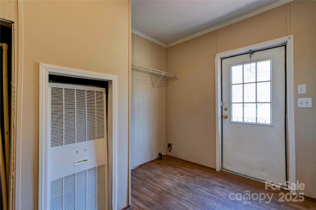 washroom featuring crown molding, a textured ceiling, a heating unit, and wood finished floors