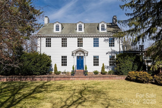 view of front of house with a chimney and a front lawn