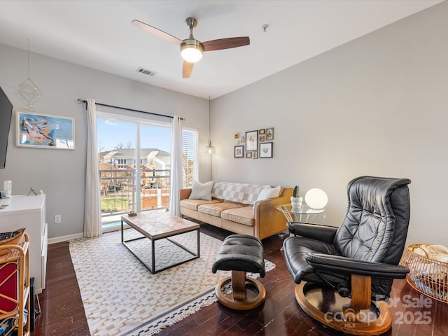 living area with visible vents, ceiling fan, baseboards, and wood finished floors