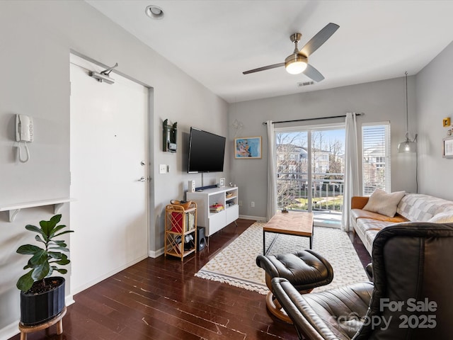 living room with baseboards, visible vents, ceiling fan, and wood finished floors