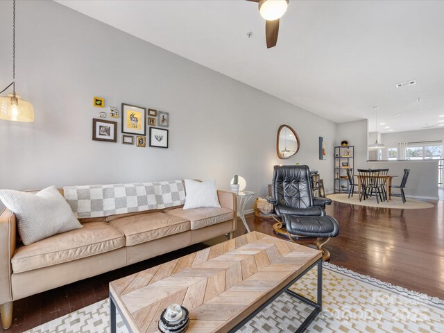 living room featuring wood finished floors, visible vents, and baseboards