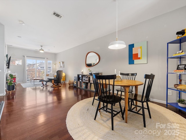 dining room with a ceiling fan, wood finished floors, visible vents, and baseboards