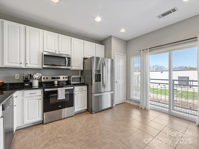 kitchen with visible vents, light tile patterned flooring, stainless steel appliances, white cabinetry, and recessed lighting