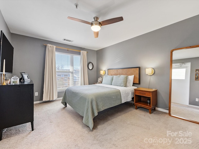 bedroom featuring light carpet, multiple windows, visible vents, and baseboards