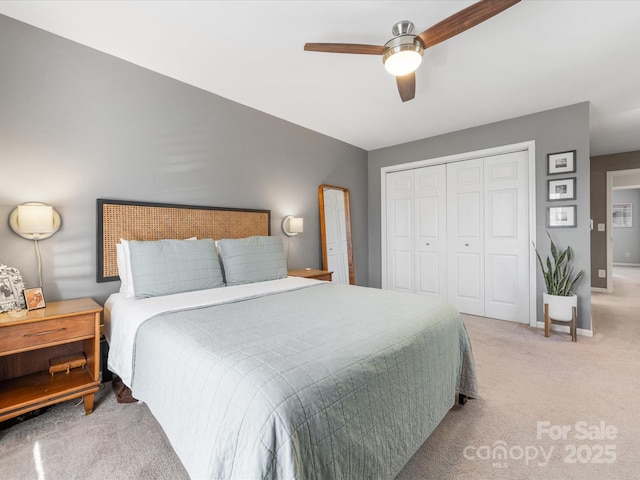 bedroom featuring a closet, light colored carpet, ceiling fan, and baseboards