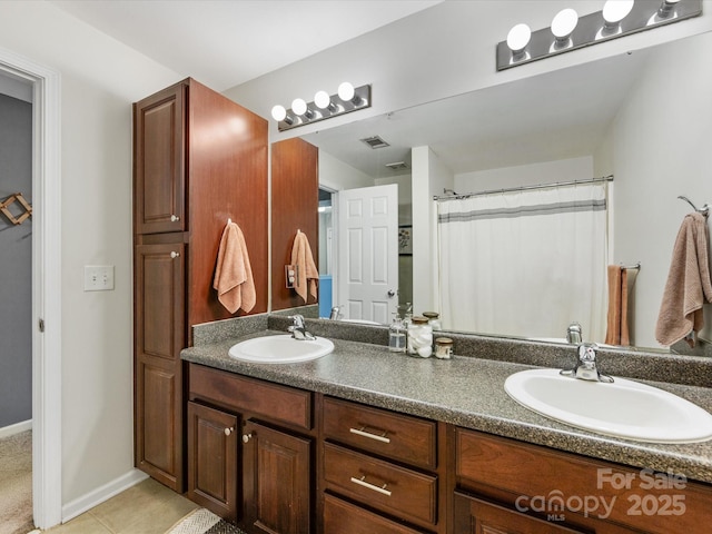 bathroom featuring double vanity, baseboards, a sink, and tile patterned floors