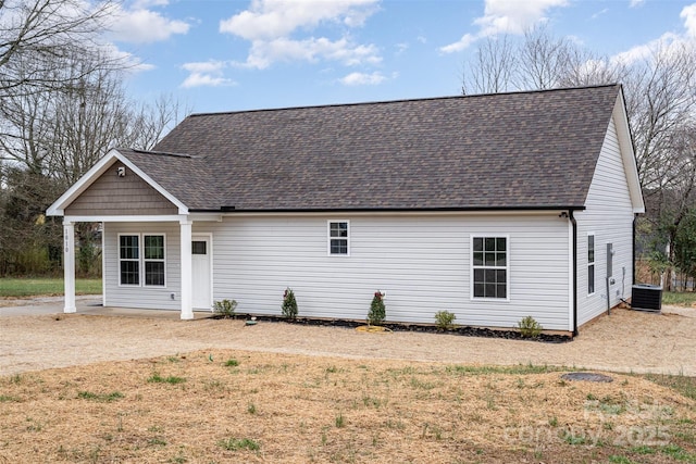 view of front of home with central AC unit and roof with shingles