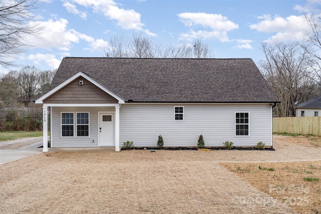 view of front of house with a shingled roof and fence