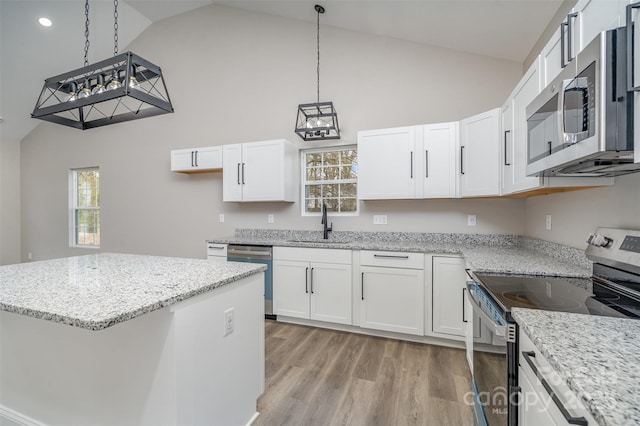 kitchen featuring stainless steel appliances, light wood finished floors, a sink, and white cabinets