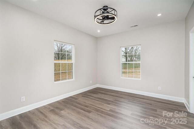 unfurnished room featuring plenty of natural light, baseboards, and visible vents