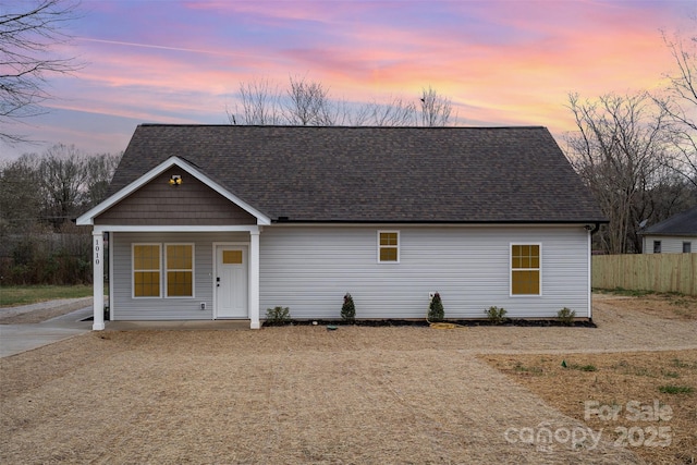 view of front of house with fence and roof with shingles