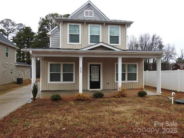 view of front of home with covered porch, fence, and board and batten siding