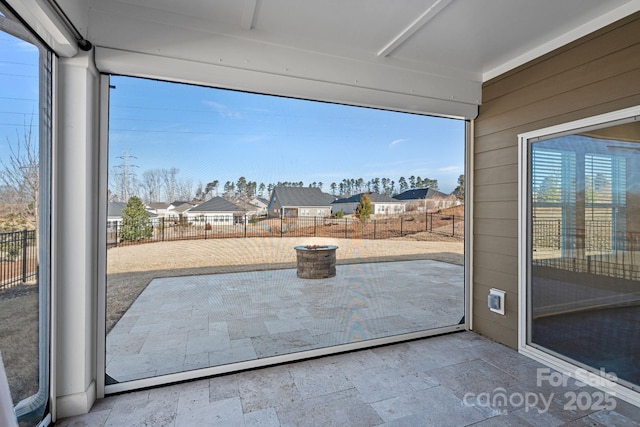 interior space with stone tile floors, a residential view, and wooden walls