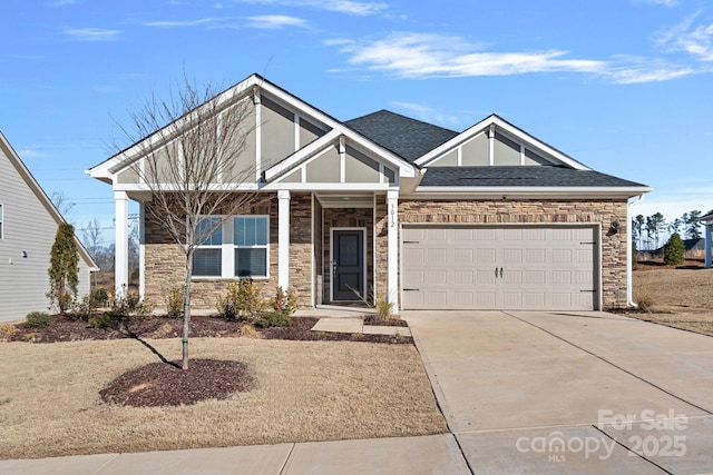 view of front facade featuring a garage, stone siding, a shingled roof, and concrete driveway