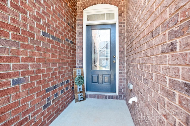 entrance to property featuring brick siding