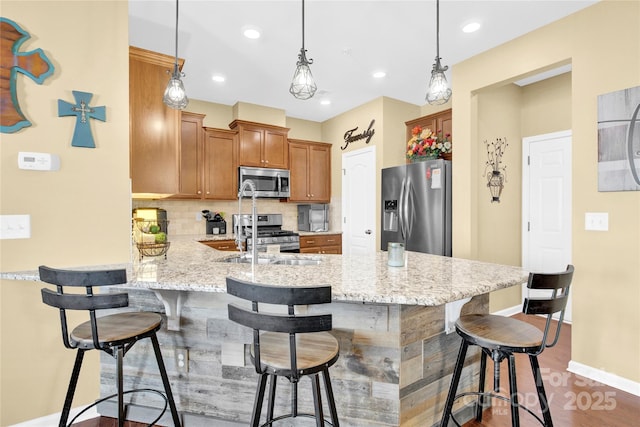 kitchen with stainless steel appliances, tasteful backsplash, a sink, a peninsula, and baseboards